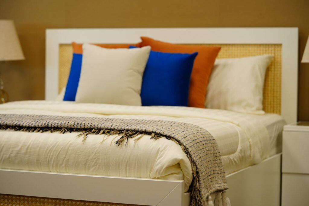 pexels photo 33349398 A stylish modern bedroom featuring vibrant pillows, soft textures, and warm ambiance in elegant decor.